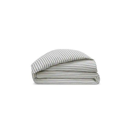 Parure de lit en coton avec motif rayé bleu et blanc, comprenant housse de couette et taie d'oreiller assortie. Le tissage de qualité et le design intemporel évoquent un style balnéaire raffiné pour une chambre élégante et apaisante.
